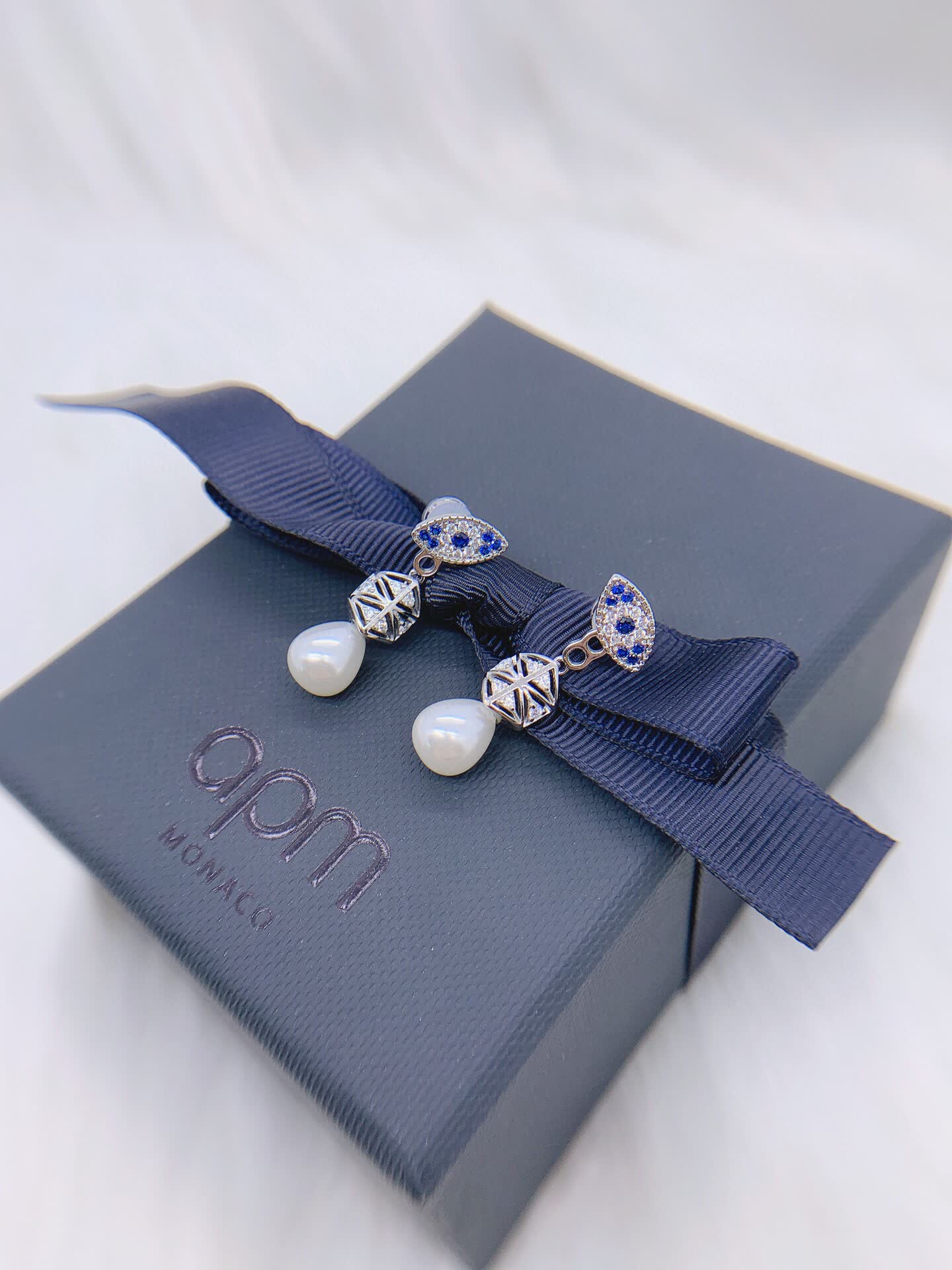 APM Monaco Elegant Pearl and Sapphire Eye Stud Earrings